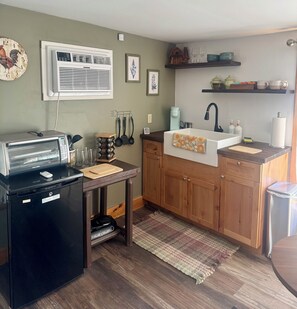 A compact kitchen with a built-in oven, a sink, and a small dining area. - Peaceful Catskills Getaway - Cozy Studio Loft (Cairo)