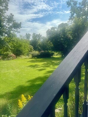 A well-maintained grassy lawn with a wooden deck railing. - Peaceful Catskills Getaway - Cozy Studio Loft (Cairo)