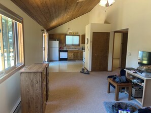 A spacious kitchen with wooden cabinets, a refrigerator, and a dining area with a table and chairs. - Charming Alpine Cabin in Alma (Fairplay)
