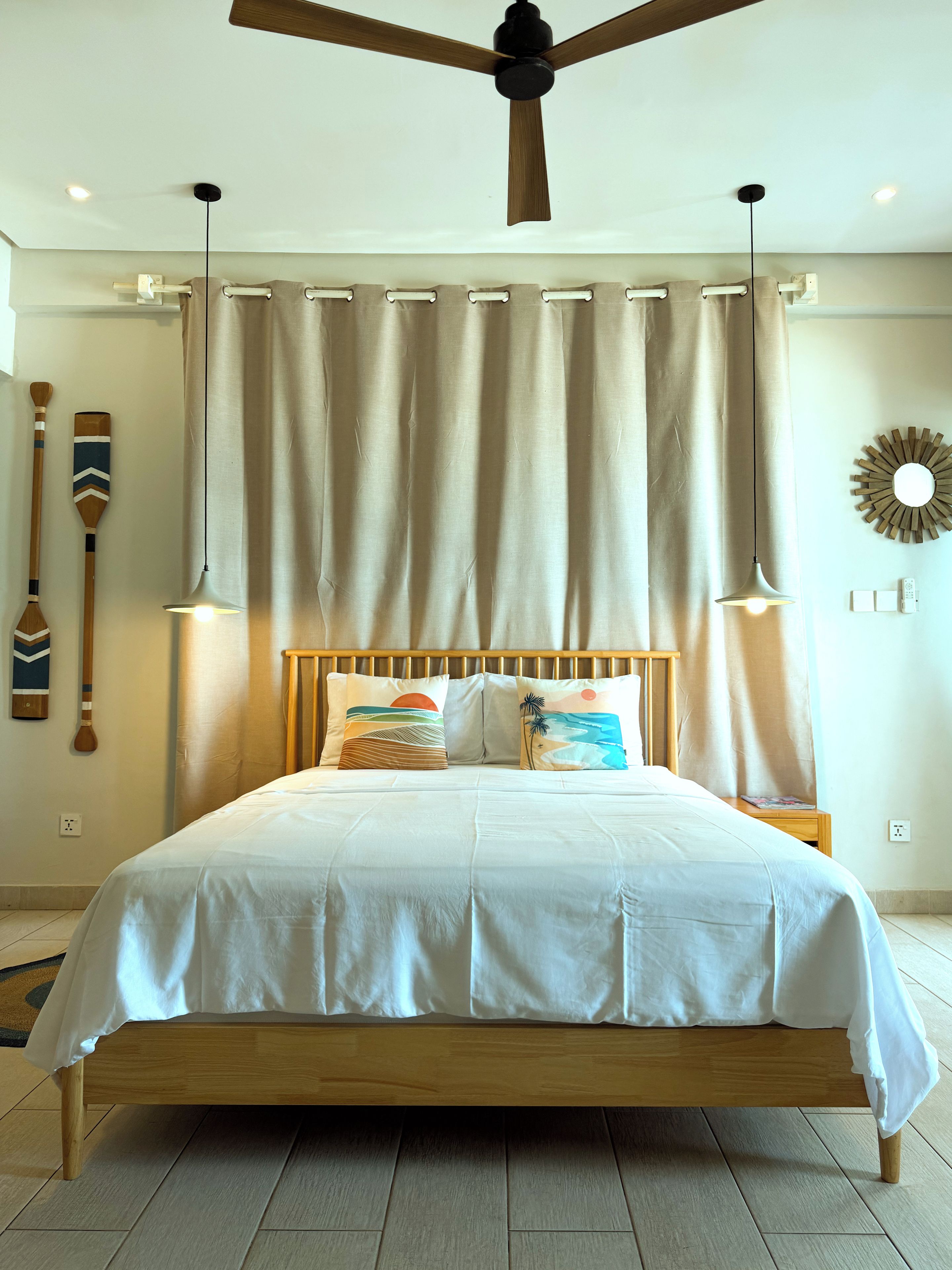 Ein Schlafzimmer mit einem hölzernen Bett, einem Deckenventilator und einer an der Wand befestigten Lampe.