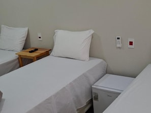 A hotel room with two beds, a small table, a refrigerator, and a wall-mounted thermostat. - Pousada Pura Vida (Barreirinhas)