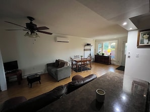 A living room with a sofa, a dining table, and a ceiling fan. - Large 5-bedroom Home Near 401.  Ideal for Work Crews & Families. (Cornwall)