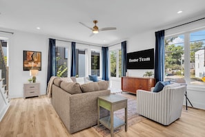 A modern living room with a sofa, armchairs, a coffee table, and a TV wall. - Nashville Hideaway | Rooftop Hot Tub & Fire Pit (Nashville)