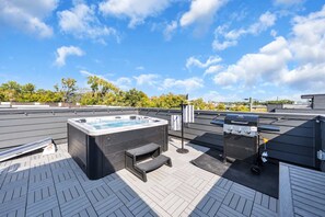 A rooftop patio with a hot tub, a grill, and a seating area. - Nashville Hideaway | Rooftop Hot Tub & Fire Pit (Nashville)