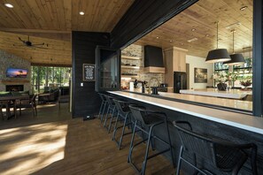 Eine moderne Küche mit Barbereich, Holzboden und Steinwand.