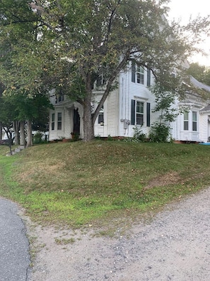A two-story white house with a large tree in front. - Cozy 1-bedroom apartment in peaceful Wilton (Wilton)