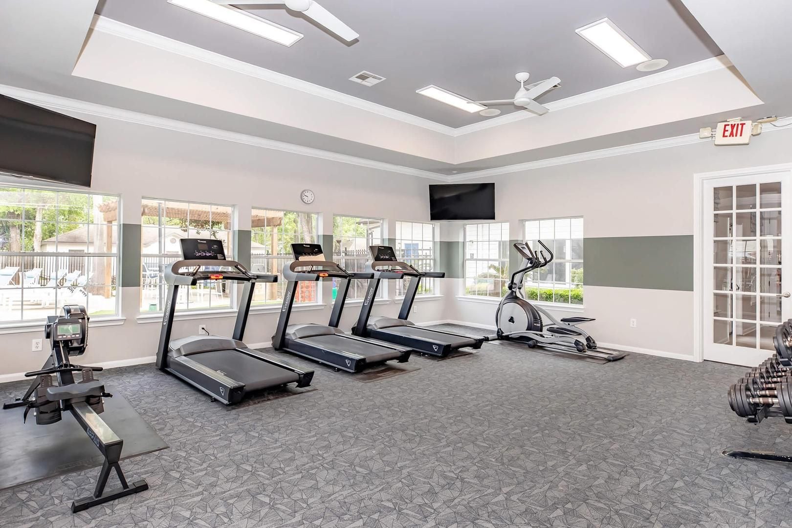 A gym with treadmills, an elliptical, and a weight bench.