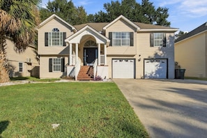 A two-story house with a front entrance, a covered porch, and two attached garages. - 5BR , Sleeps 14 , Central to Downtown & Tybee (Savannah)