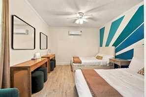A hotel room with two beds, a desk, a ceiling fan, and an air conditioning unit. - 5BR , Sleeps 14 , Central to Downtown & Tybee (Savannah)