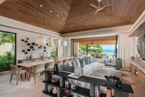 A spacious living area with a wooden ceiling, a dining table, and a view of the ocean. - Beachfront 5BR Villa w/ Pool, big garden, Ocean Views & Premier Golf Membership (Punta de Mita)