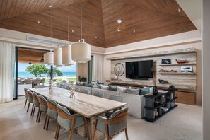 A spacious living area with a wooden ceiling, a large dining table, and a seating arrangement. - Beachfront 5BR Villa w/ Pool, big garden, Ocean Views & Premier Golf Membership (Punta de Mita)