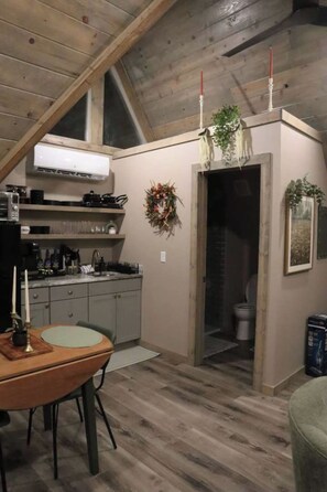 A compact kitchen with a dining area, a small bathroom, and a loft space with a sloped ceiling. - Twilight at Lux in the Gorge - Hot Tub - Fishing - Shared Pond with Kayaking, Swimming, & Pedal Boat - Game Room with Pool Table, Foosball, Ping Pong, Air Hockey, and More! (Campton)