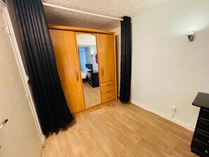 A room with a wooden wardrobe, a mirror, and a black dresser. - aroma house (Tulle)