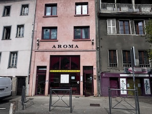 A building with a sign reading 'AROMA' and a 'RESTAURANT INDIEN' sign below it. - aroma house (Tulle)