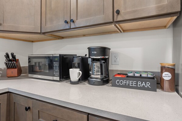 Eine Küche mit Kaffeemaschine, Mikrowelle und einer Theke mit Kaffeeschild.