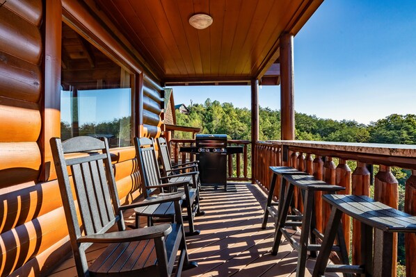 A wooden deck with outdoor seating and a barbecue grill. - Mountain Views, 2 King Suites, Hot Tub, Cabin with AC in peaceful Sevierville (Sevierville)