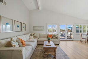 A living room with a sofa, coffee table, and artwork on the wall. -  Beautifully remodeled 3-bedroom home  located close to the beach in Cardiff, CA (Encinitas)