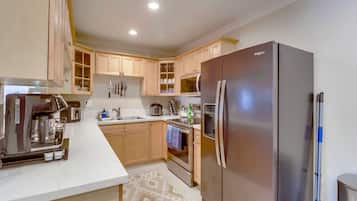 Eine moderne Küche mit Backofen, Edelstahlkühlschrank und Holzschränken.
