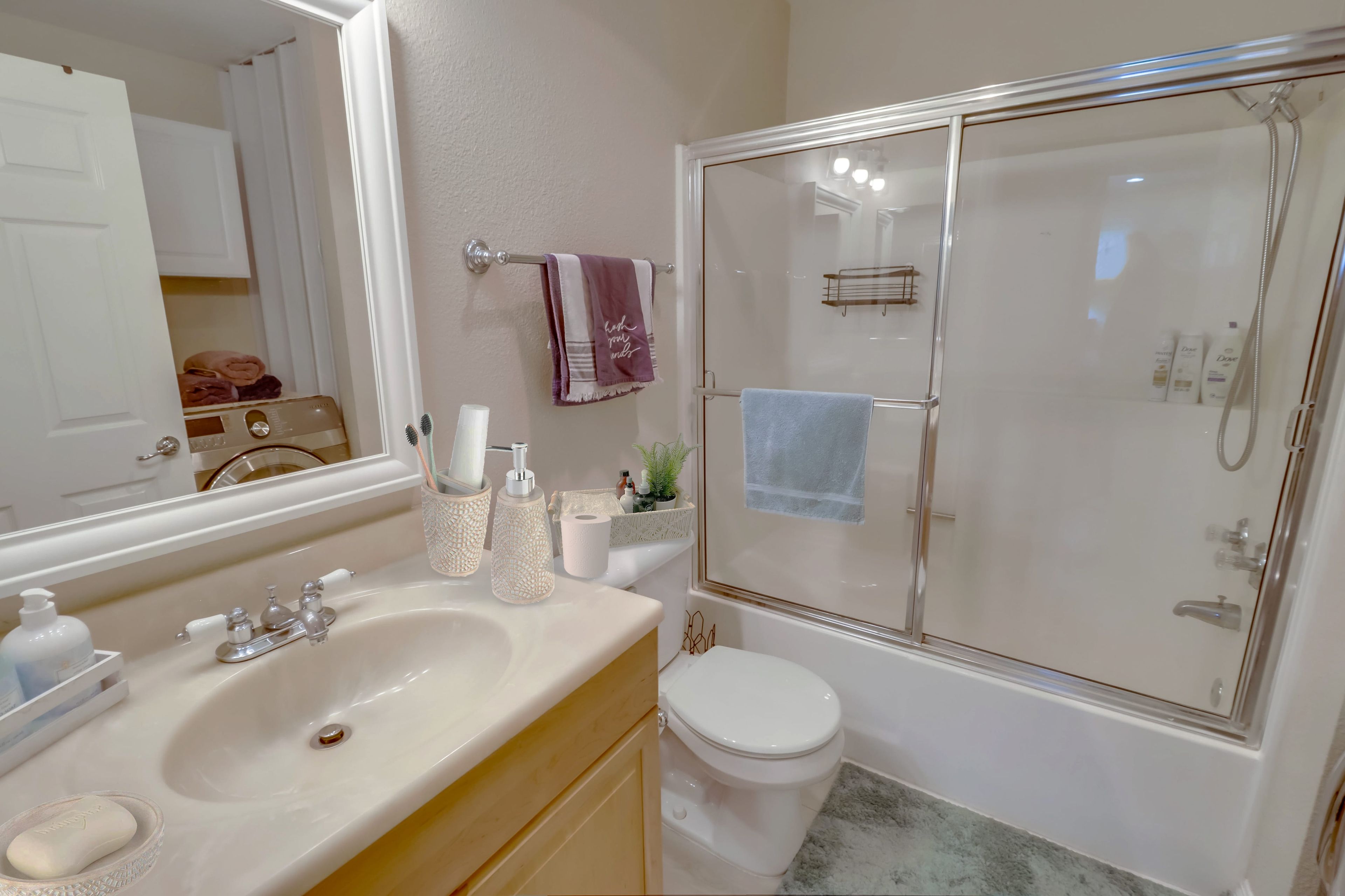 A modern bathroom with a sink, toilet, and glass-enclosed shower.