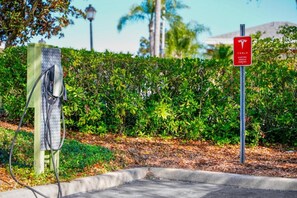 Estação de carregamento para veículos elétricos Tesla, com placa indicando vaga exclusiva para Tesla.