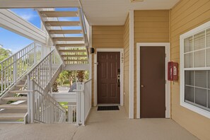 A covered outdoor area with a staircase leading to a door marked with the number 107. - 2BR Bahama Bay Condo Near Disney (Davenport)