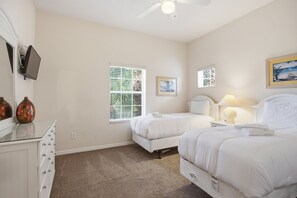 A hotel room with two beds, a ceiling fan, a desk with a computer, and a window with blinds. - 2BR Bahama Bay Condo Near Disney (Davenport)