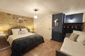 Ein Schlafzimmer mit Bett, Nachttischen, einem Schminktisch, einem Spiegel, einem Kleiderschrank und einer Tür.