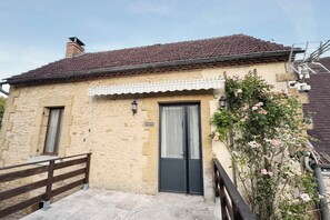 A two-story building with a stone facade, a tiled roof, and a black door. - La Campanule – Spacious holiday home for 6 people with private hot tub (Meyrals)