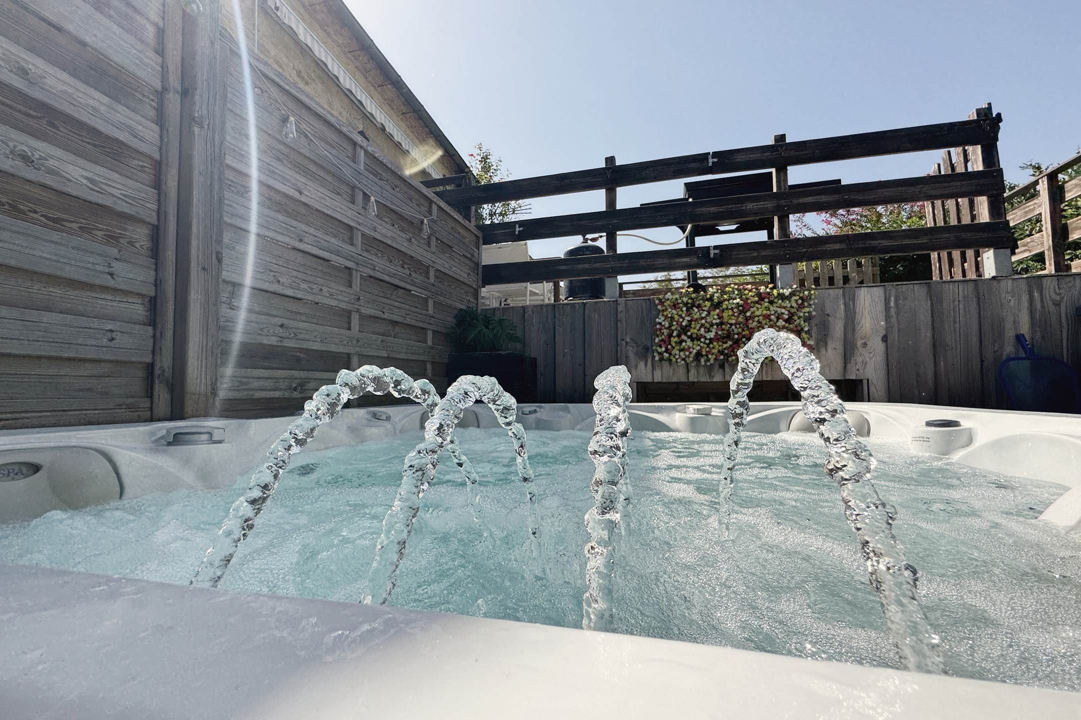 Jacuzzi amb dutxes d'aigua en un jardí.
