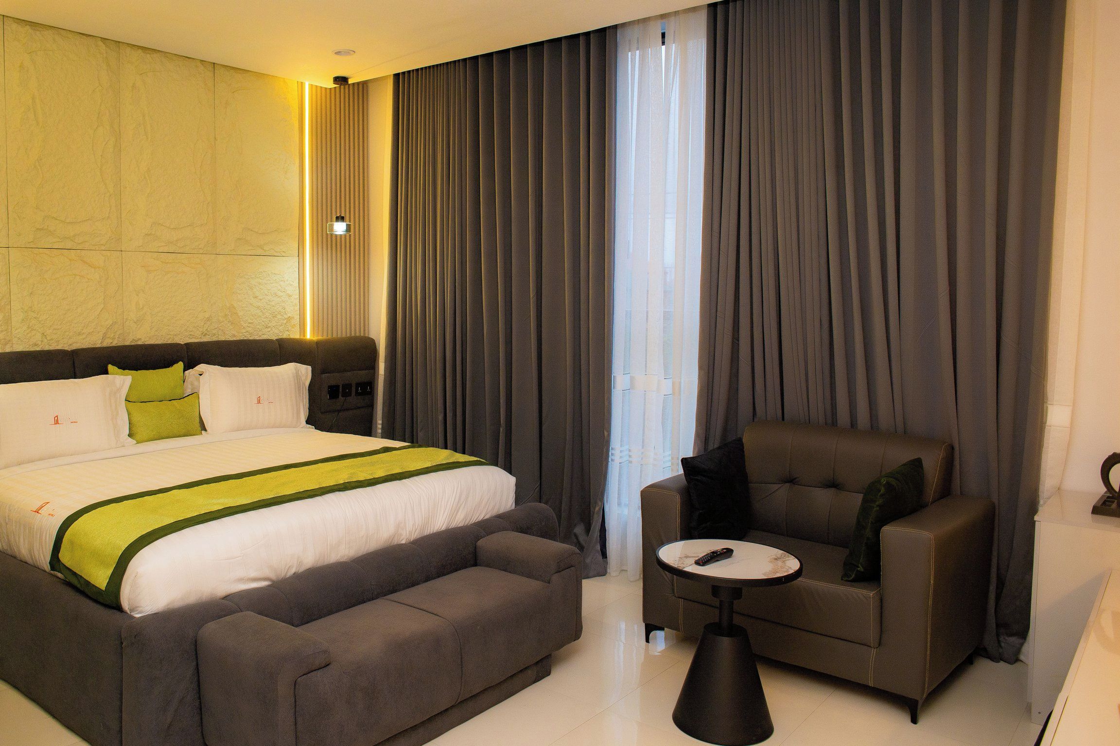 Une chambre d’hôtel avec un grand lit, un canapé, une petite table et une chaise.
