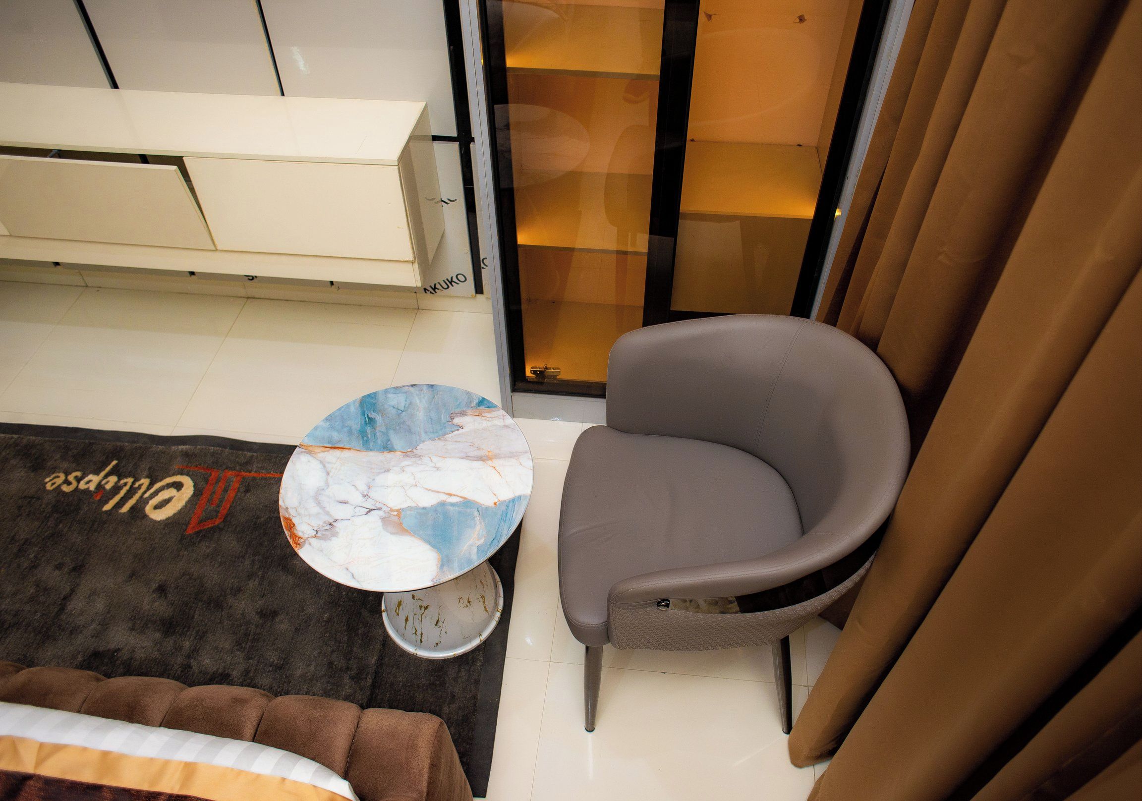 A small room with a sofa, a chair, a coffee table, and a sliding glass door.