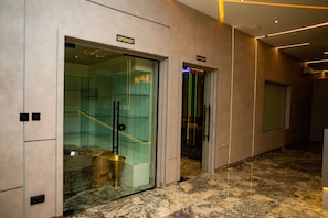 A modern interior with a marble floor, a glass-walled room labeled 'SUPERMART,' and a 'RESTAURANT' sign. - Ellipse Hotels (Lagos)