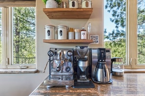 A kitchen with a coffee machine, a grinder, and storage shelves. - Granite View Prescott Cabin - Hot Tub & Game Room Near Whiskey Row (Prescott)