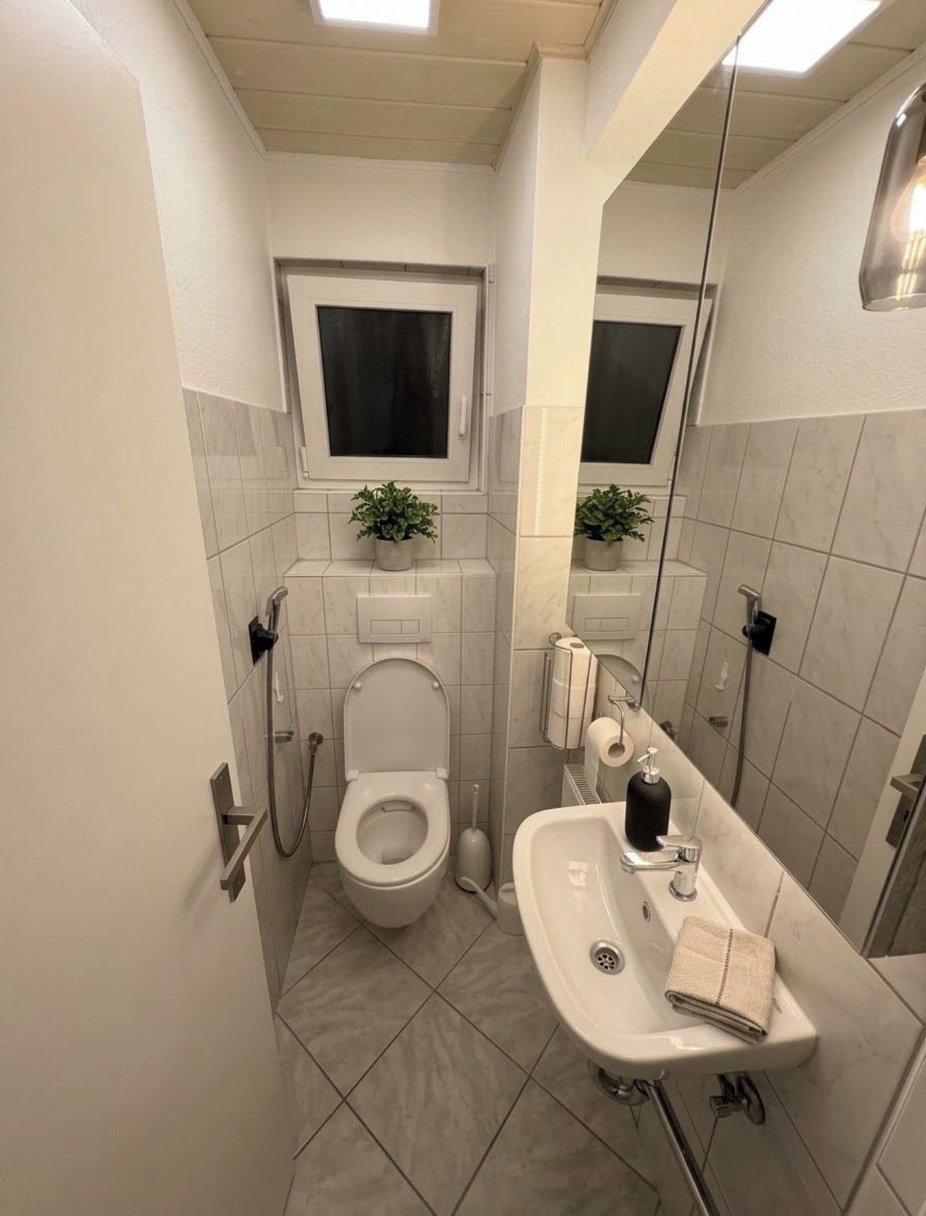 Ein kleines Badezimmer mit Toilette, Bidet, Waschbecken und Spiegel.