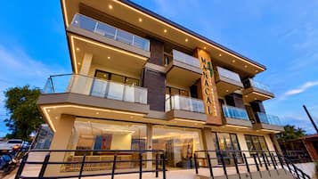 A multi-story hotel with a prominent sign, balconies, and a staircase leading to the entrance.