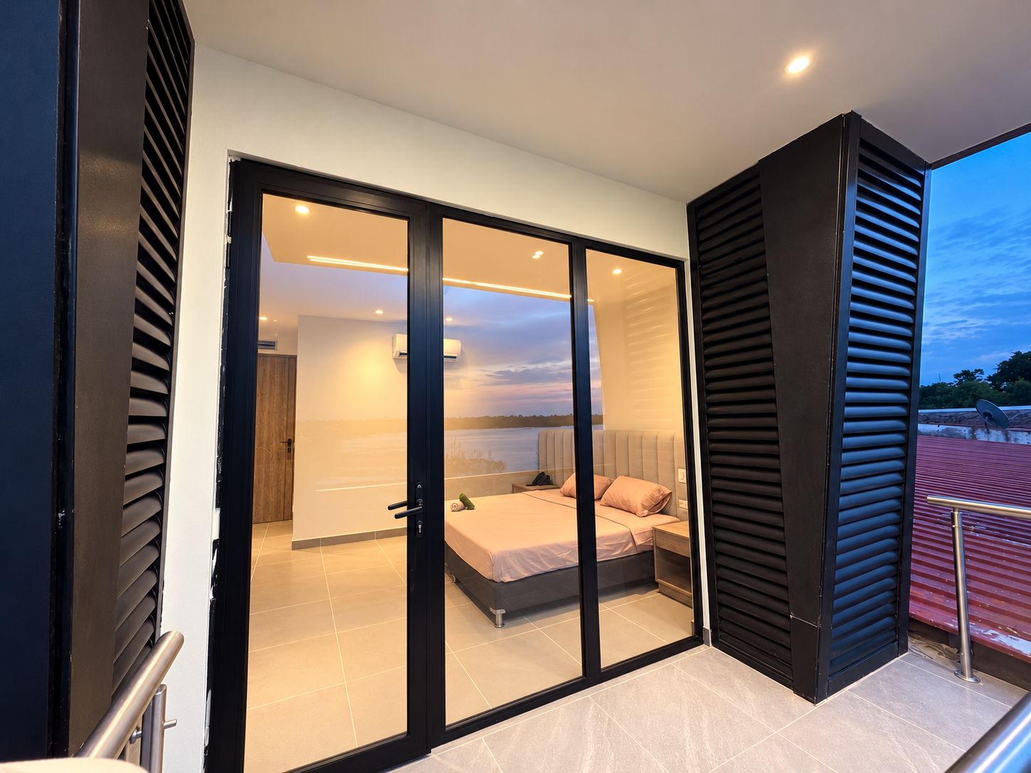 Un dormitorio moderno con una puerta de vidrio corrediza que da a un balcón.