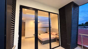 Un dormitorio moderno con una puerta de vidrio corrediza que da a un balcón.