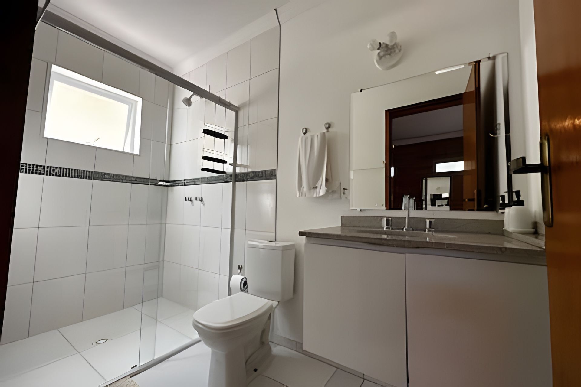 A modern bathroom with a shower, toilet, and sink.