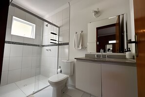 Une salle de bain moderne équipée d’une douche, de toilettes et d’un lavabo.