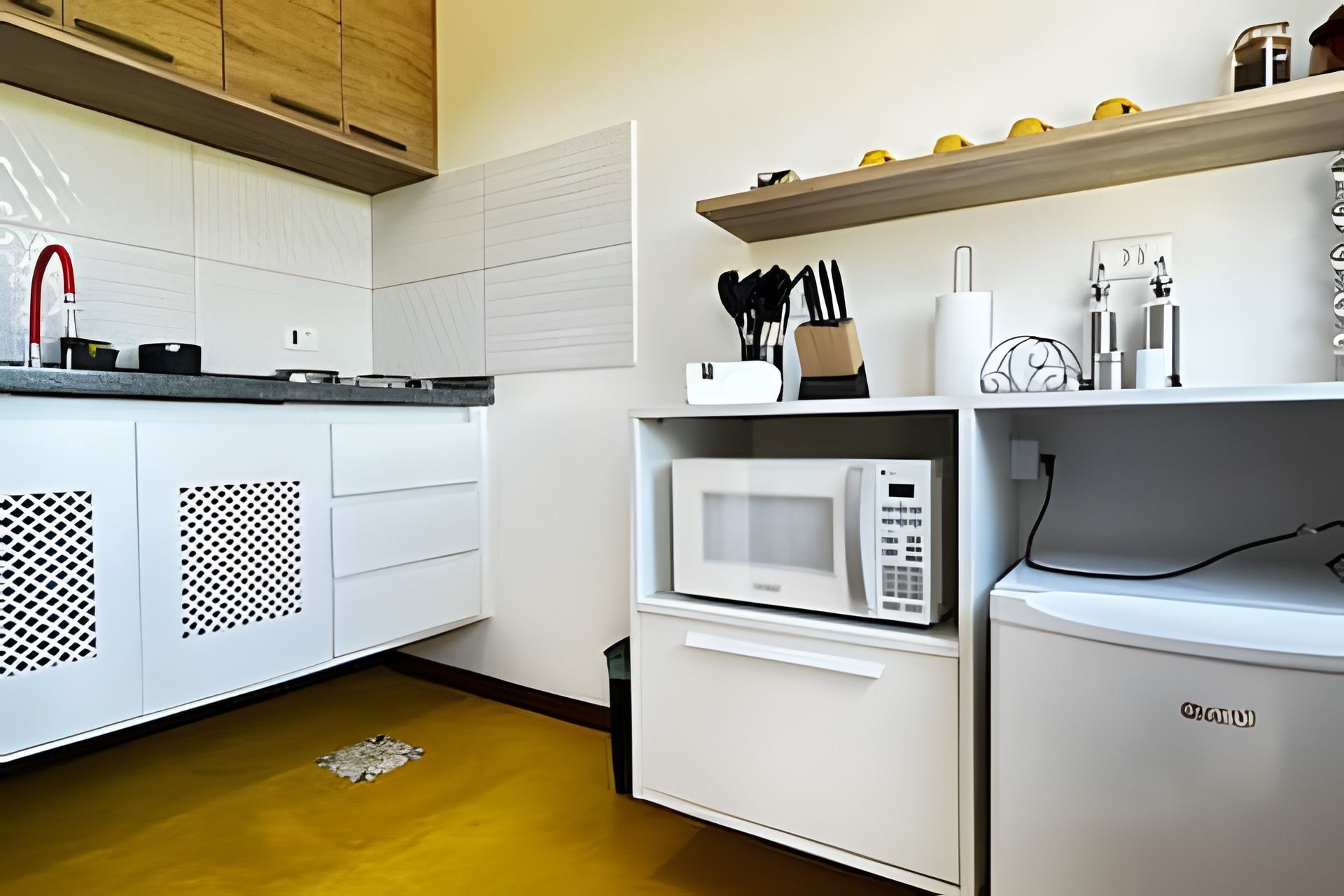 A kitchen with a microwave, a sink, and cabinets.
