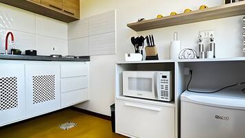 A kitchen with a microwave, a sink, and cabinets.