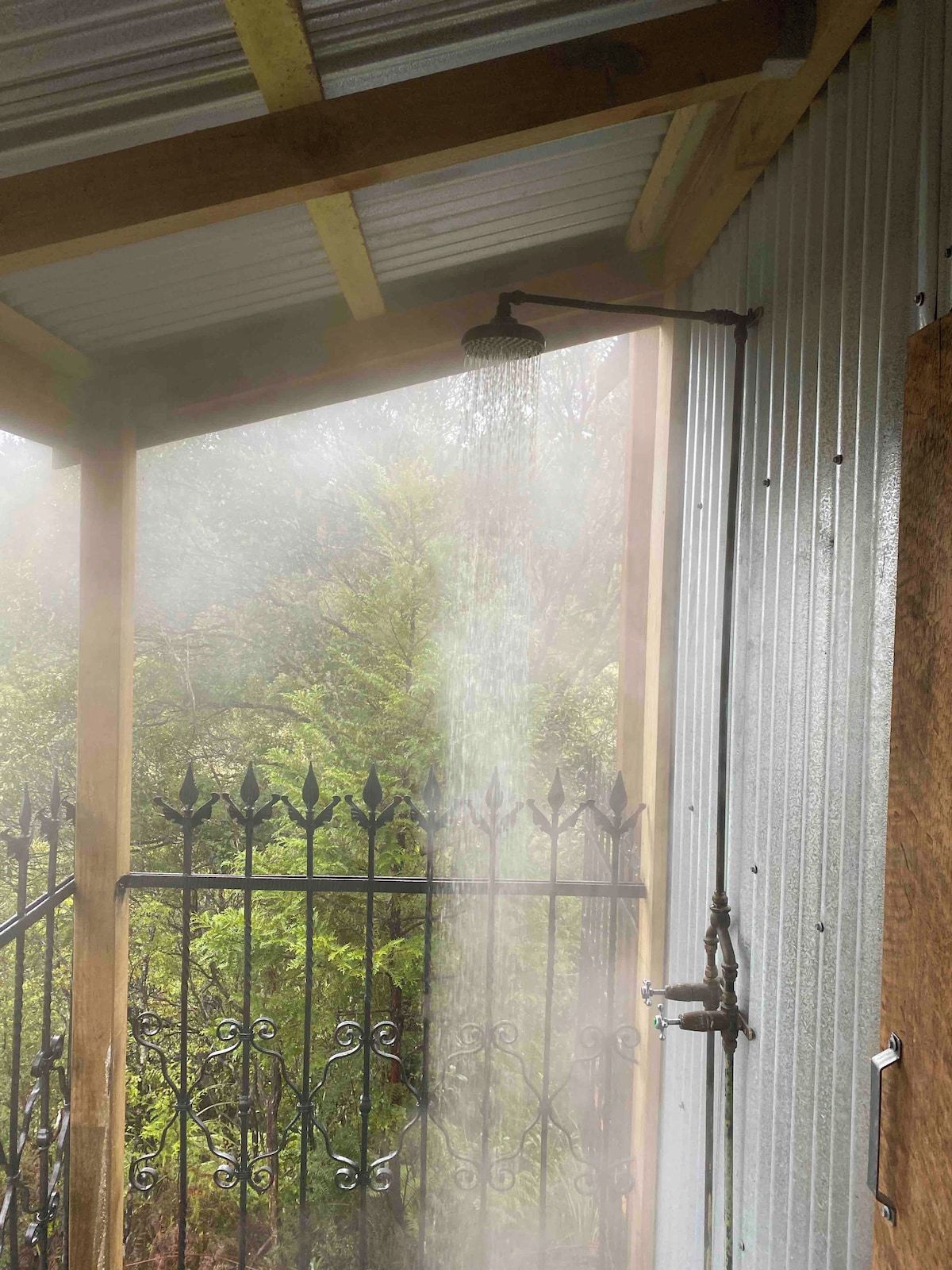 A covered outdoor area with a metal fence and a water feature.