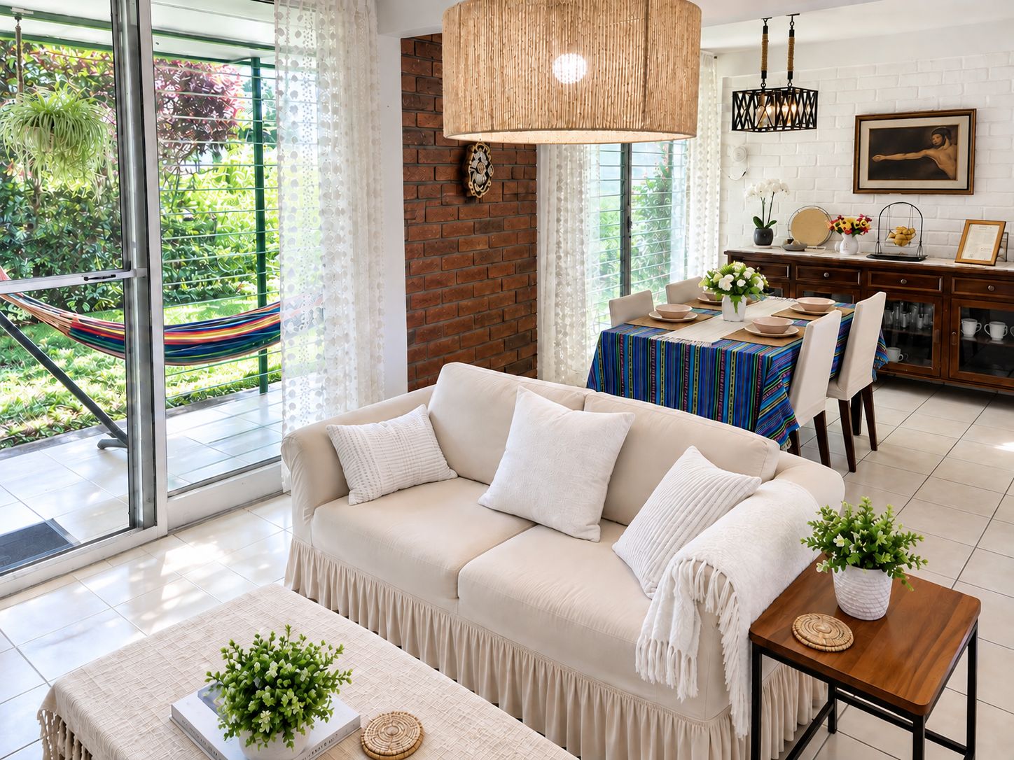 Un salon moderne avec un canapé, une table à manger et une vue sur un jardin grâce à de grandes fenêtres.