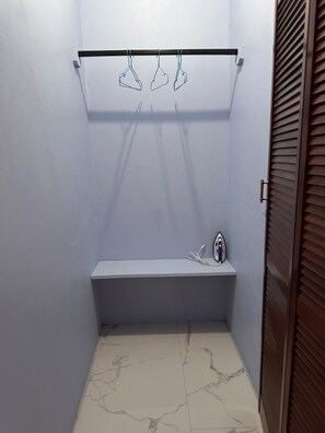 Ein kleines Badezimmer mit einer Sitzbank, einem Handtuchhalter und einer Wandheizung.