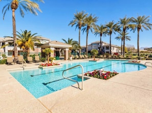 A swimming pool with lounge chairs and palm trees, surrounded by buildings. - Remodeled 3BR Kierland | Garage, Pool, Spa, Golf (Scottsdale)