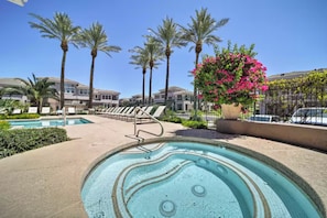 A swimming pool area with lounge chairs, palm trees, and a hot tub. - Black & Gold Luxe | No Stairs | Pool & Spa (Scottsdale)