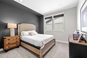 A bedroom with a bed, a nightstand, a lamp, a window, and a desk with a chair. - 4b3b modern house in Ontario/Model Home/Two Living room/AC/WIFI/back yard (Ontario)