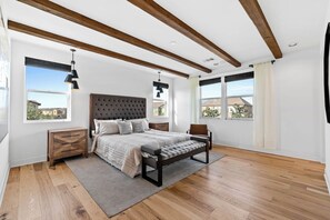 A bedroom with a large bed, a bench, a nightstand, and a window with a view of houses. - 4b3b modern house in Ontario/Model Home/Two Living room/AC/WIFI/back yard (Ontario)