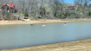 A river with boats and a building in the background. - Beav-o-rama nights (Fayetteville)