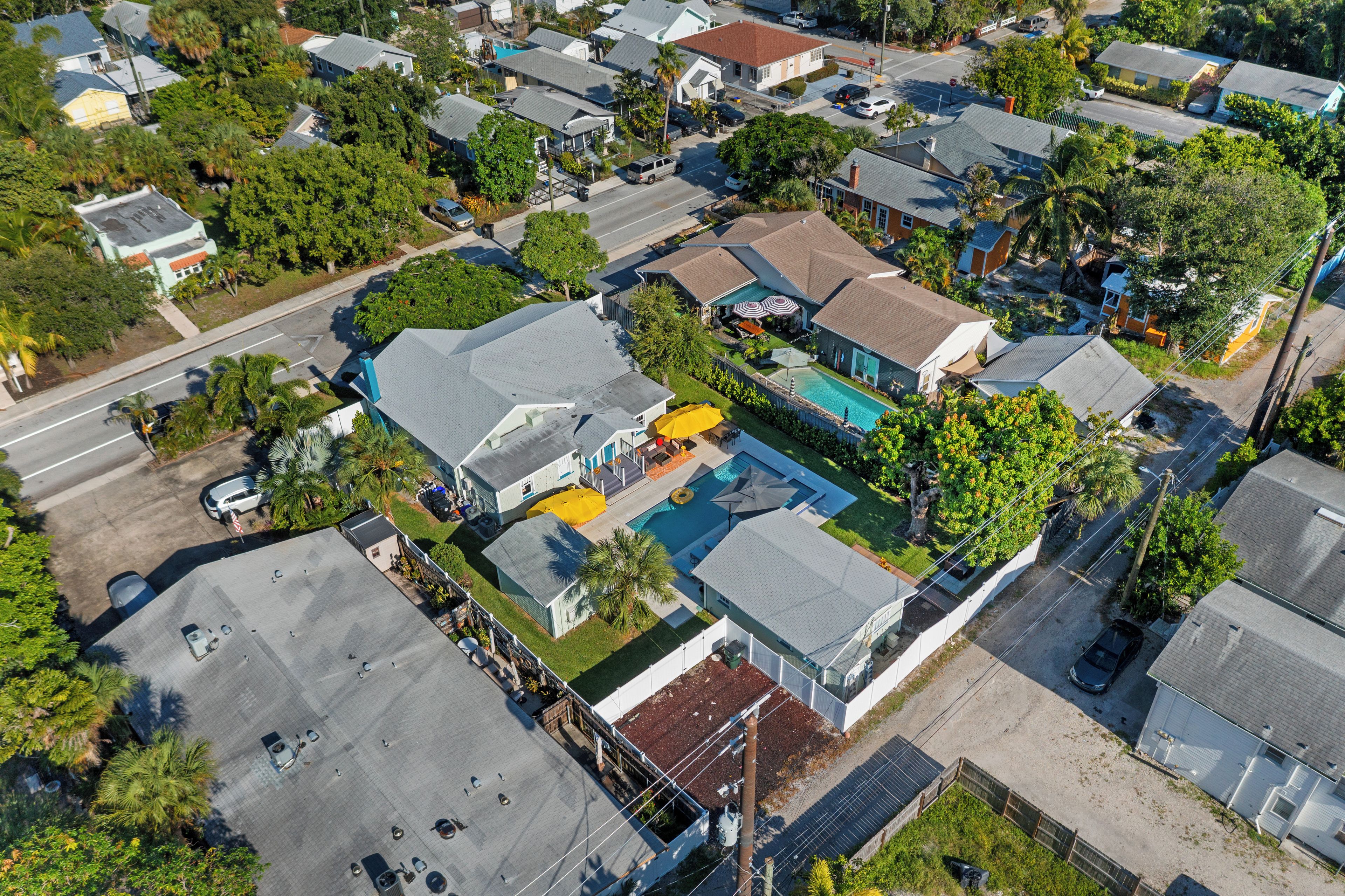 Vista aérea de una zona residencial con casas, piscina y calle.
